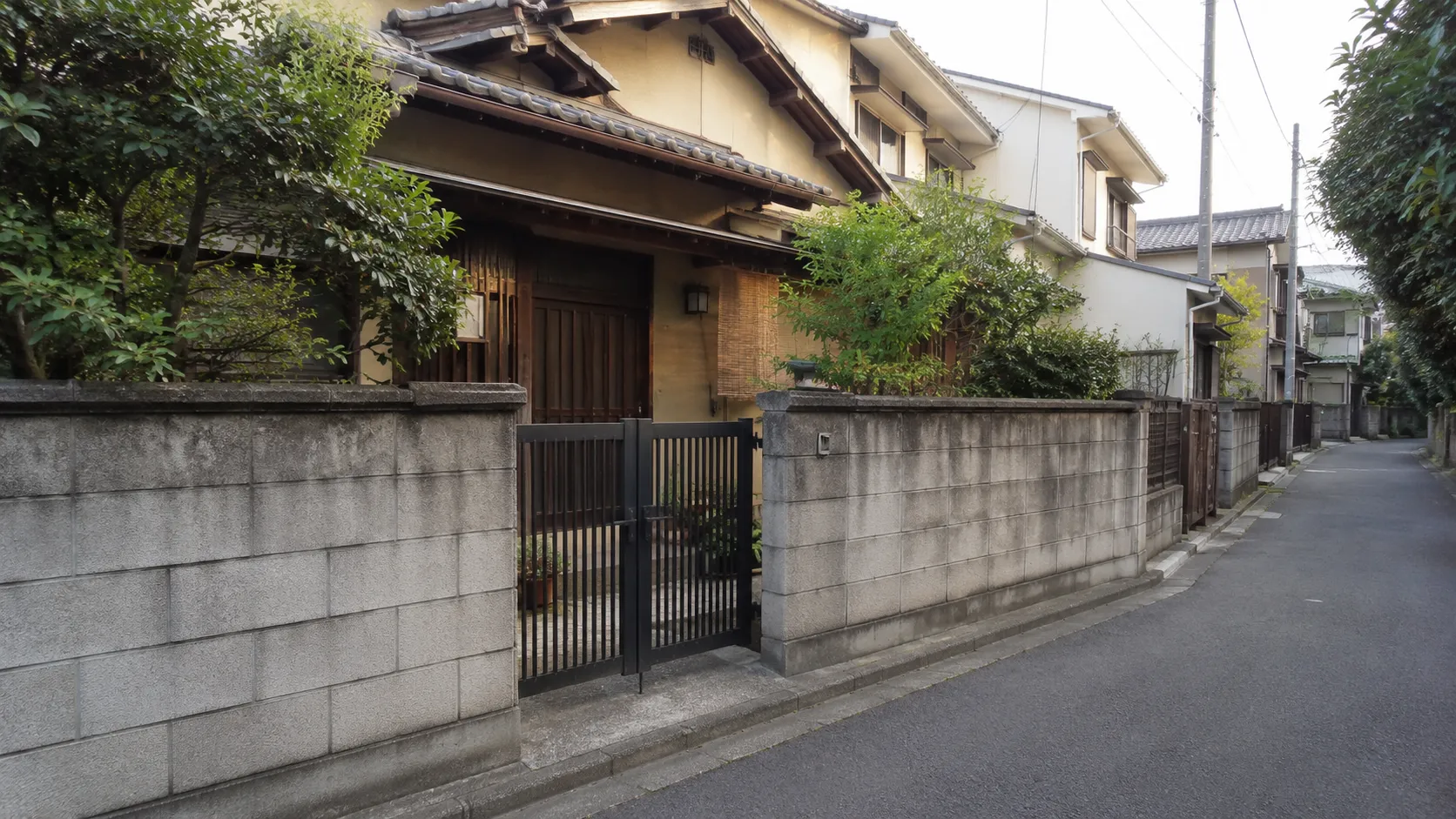 幅の狭い2項道路に面した古い住宅と塀のイメージ