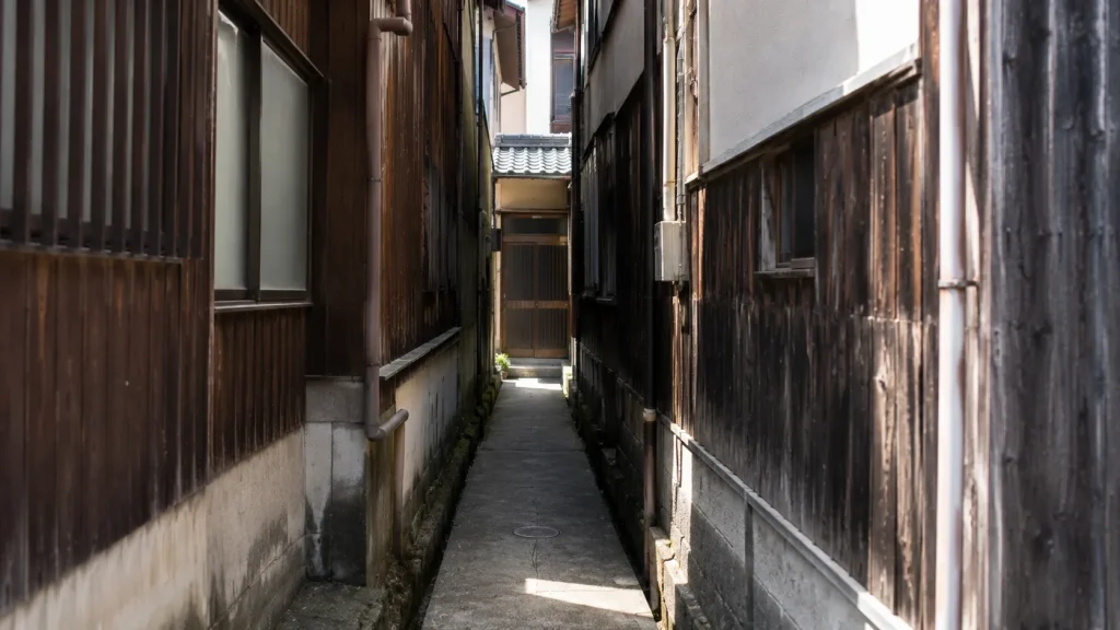人がやっと通れる細い路地の奥に建つ住宅のイメージ